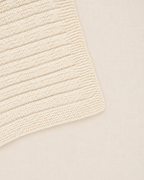 Detalle de la punta de la manta para bebé Clara tejida a mano con patrón de triángulos sutiles Baby Alpaca - Nuna Nina