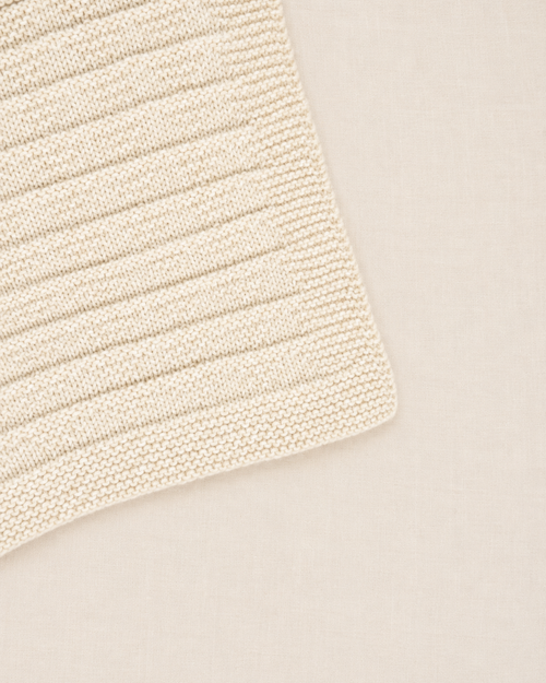 Detalle de la punta de la manta para bebé Clara tejida a mano con patrón de triángulos sutiles Baby Alpaca - Nuna Nina